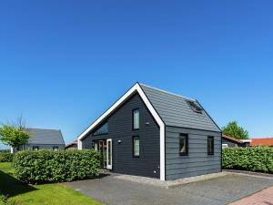 KattendijkeにあるModern Holiday Home in Kattendijke with a Gardenの灰色の屋根の黒い家