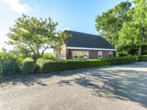 a red brick house with a black roof at Peaceful vacation home in Finsterwolde with wide views in Finsterwolde