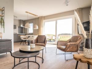 a living room with two chairs and a table at fantastic bungalow on Texel in De Cocksdorp