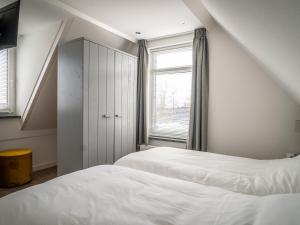 een slaapkamer met 2 bedden en een raam bij fantastic bungalow on Texel in De Cocksdorp