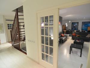 a living room with a staircase and a living room with a couch at Cosy villa in the middle of the woods in Doornspijk in Doornspijk