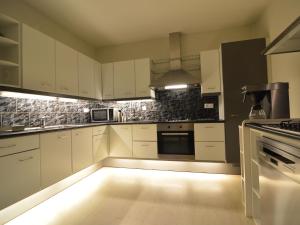a kitchen with white cabinets and a light on the floor at Family villa w Trampoline, Pool in Doornspijk