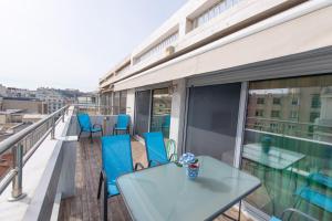 アテネにあるRooftop apartment in the center of Athensのバルコニー(ガラステーブル、青い椅子付)