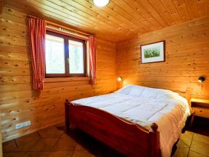 een slaapkamer met een bed in een houten hut bij Finnish house with enclosed garden near the Salland Ridge in Holten