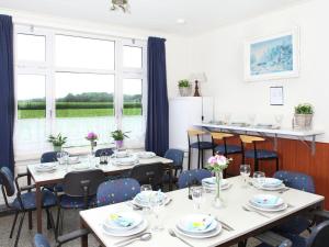 a dining room with tables and chairs and a window at Detached farmhouse with play loft in Neede