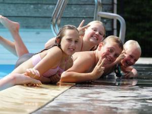 un grupo de niños en una piscina en Modern chalet with two terraces and near a pond, en De Bult