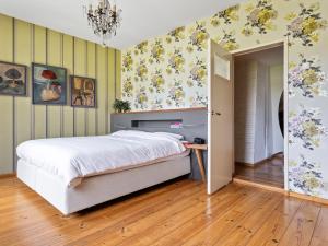 una camera da letto con un letto e fiori sul muro di Spectacular Farmhouse with Terrace Garden Parking Parasol a Oterleek