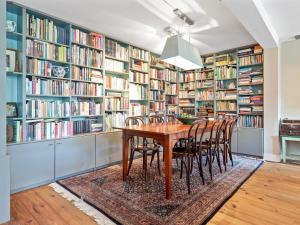 una sala da pranzo con biblioteca, tavolo e sedie in legno di Spectacular Farmhouse with Terrace Garden Parking Parasol a Oterleek