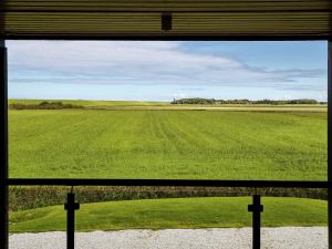 a view of a green field from a window at Modern large villa on the mudflats in Friesland in Wierum