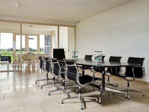 a dining room with a black table and chairs at Modern large villa on the mudflats in Friesland in Wierum