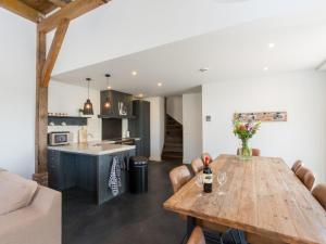 a kitchen and a dining room with a wooden table at Family Home in Zeeland near Oranjezon Beach in Vrouwenpolder