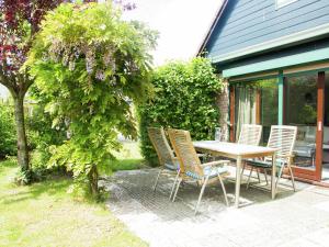 una mesa y sillas en un patio en Lovely holiday home in Wolphaartsdijk en Wolphaartsdijk