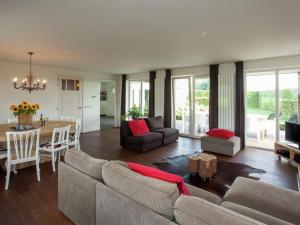 een woonkamer met een bank en een tafel bij Luxurious holiday home with wellness, in the middle of the North Brabant nature reserve near Leende in Leende