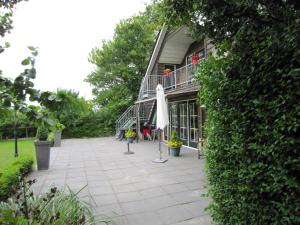 a patio with an umbrella next to a building at Luxury Holiday Home In Noordbeemster in Noordbeemster
