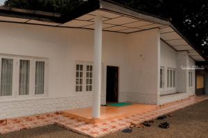 un gran edificio blanco con porche y columna en White House en Kegalle