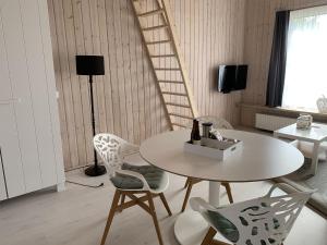 Habitación con mesa, sillas y escalera. en Luxury Holiday Home in Zoutelande with Private Terrace, en Zoutelande