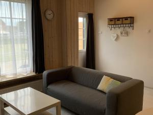 sala de estar con sofá, mesa y reloj en Luxury Holiday Home in Zoutelande with Private Terrace, en Zoutelande