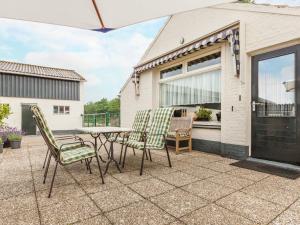 a patio with a table and chairs on a patio at Cozy Holiday Home in Oisterwijk with Swimming Pool in Oisterwijk