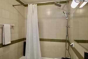 a bathroom with a shower with a white shower curtain at Our Dream Downtown Experience by AnaLodges in Funchal