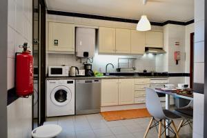 eine Küche mit einer Waschmaschine und einem Tisch in der Unterkunft Our Dream Downtown Experience by AnaLodges in Funchal