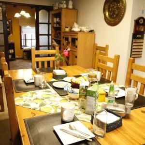 - une table à manger avec des assiettes et de la vaisselle dans l'établissement Hospedaje familiar Gloria, à Punta Arenas