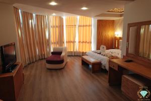 ein Hotelzimmer mit einem Bett, einem Stuhl und einem TV in der Unterkunft El Yacouta in Tétouan