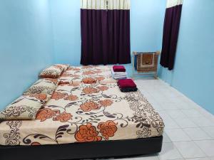 een slaapkamer met een groot bed met bloemen erop bij Hazim Homestay Pakej 1 in Changlun