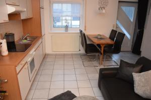 eine Küche und ein Esszimmer mit einem Tisch und einem Sofa in der Unterkunft Haus Luzia in Sankt Aldegund