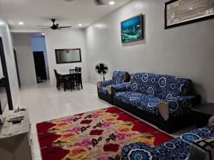 een woonkamer met een bank en een tapijt bij Hazim Homestay Pakej 1 in Changlun