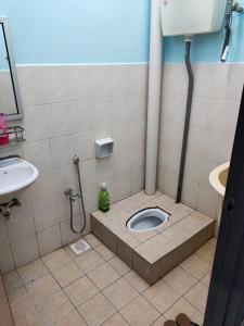 een badkamer met een toilet en een wastafel bij Hazim Homestay Pakej 1 in Changlun