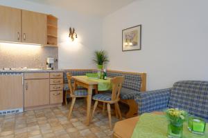 cocina y sala de estar con mesa y sofá en Haus-Schneider-Sepp, en Ettal