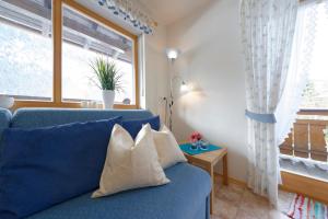 Sofá azul en la sala de estar con ventana en Haus-Schneider-Sepp, en Ettal