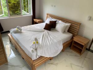 sypialnia z łóżkiem z białą pościelą i poduszkami w obiekcie CAM Getaway Villa w mieście Praslin