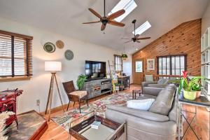 a living room with a couch and a ceiling fan at High-End Canalfront Paradise with Dock and Kayaks! in Kill Devil Hills