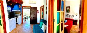 a living room with colorful furniture and a kitchen at Estudios Bahia de la Plata in Zahara de los Atunes