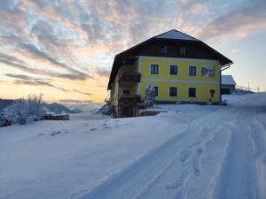een huis in de sneeuw met de zonsondergang erachter bij Mitterhirschberg, Familie Schweighuber in Waidhofen an der Ybbs