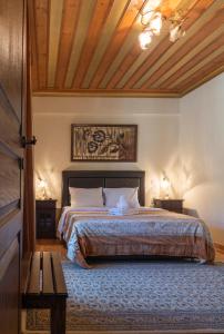 a bedroom with a large bed with a wooden ceiling at Aggelon Katafygio in Asprangeloi