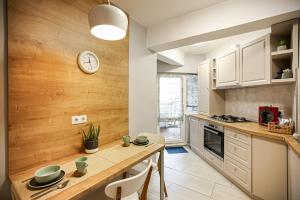 a kitchen with a table and a clock on the wall at City Apartment Cipariu in Cluj-Napoca