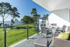 GarzにあるAppartement "Haffglück" mit Penthouseflair - Oase am Haffのバルコニーにテーブルと椅子が置かれたパティオ