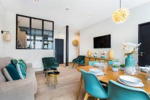 - un salon avec une table et des chaises vertes dans l'établissement HSH Alexandre Dumas Lovely Apartment 2BR-6P, à Paris