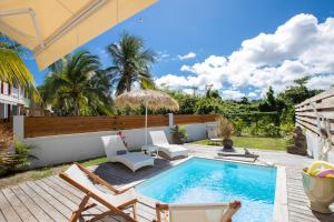 a backyard with a swimming pool and chairs and a fence at Life is Good in SXM in Saint Martin