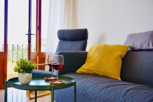 ソリェルにあるAlojamiento Migjorn - Apartaments tres Ventsのソファの横のテーブルにワイン1杯