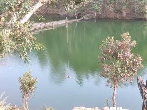 um balanço no meio de um corpo de água em Begnas lake front rental home em Deorāli
