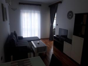 a living room with a couch and a television at Pleasing place in Fažana
