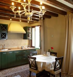 une cuisine avec une table et des chaises ainsi qu'un lustre dans l'établissement Wow suite 5 min from San Marco, à Venise