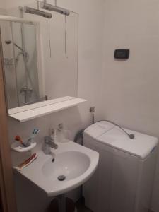 a bathroom with a sink and a mirror and a toilet at Pleasing place in Fažana +17 photos