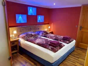 グレーブミングにあるSonnenalm Mountain Lodgeのベッドルーム1室(壁に青い照明が付いたベッド1台付)