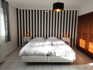 ein Schlafzimmer mit einem weißen Bett und zwei Nachttischen in der Unterkunft Luxurious Villa in Stavelot with Sauna and Pool in Stavelot