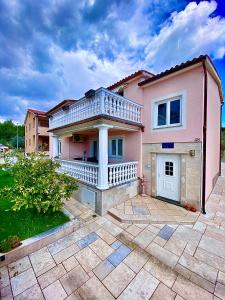 Casa rosa con balcón en el patio en Apartments Gajić, en Fažana