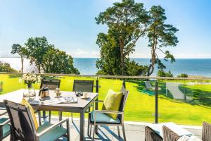 a table and chairs on a balcony with a view of the ocean at Appartement "Mondstein" mit Penthouseflair - Oase am Haff in Garz-Usedom